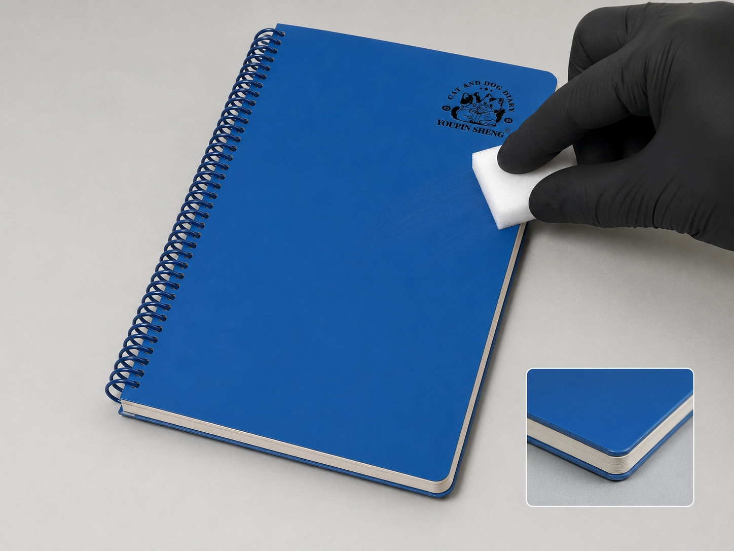 Custom notebook cover showing dark soft-touch matte finish, scuff testing, and board edge construction under retail quality control lighting